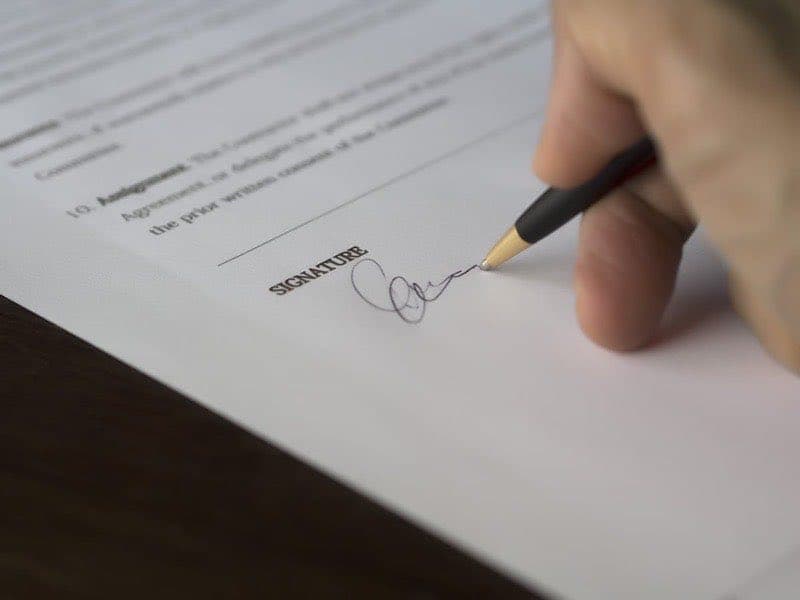 Person signing a professional contract document